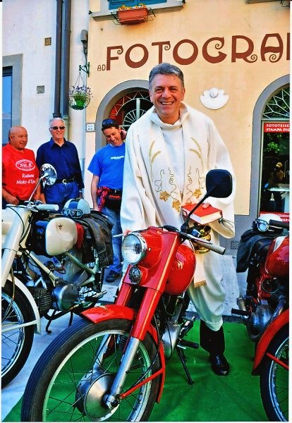 Una immagine particolare e simpatica; il pievano di Barberino don Stefano Ulivi, sopra una moto d’epoca. 