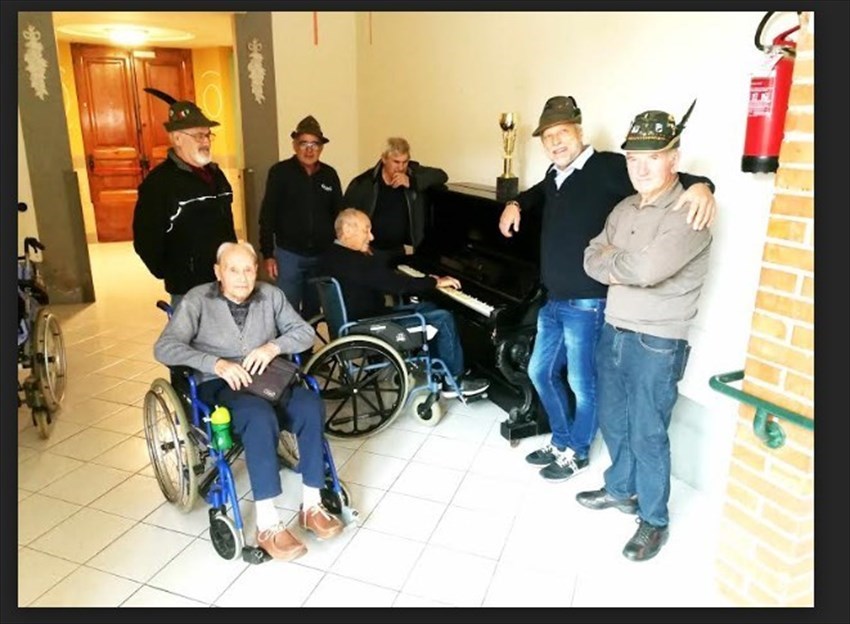 Prima del pranzo, un anziano ospite della Casa di Riposo Mauro Volpini, un bravo pianista, allieta gli alpini e gli amici.