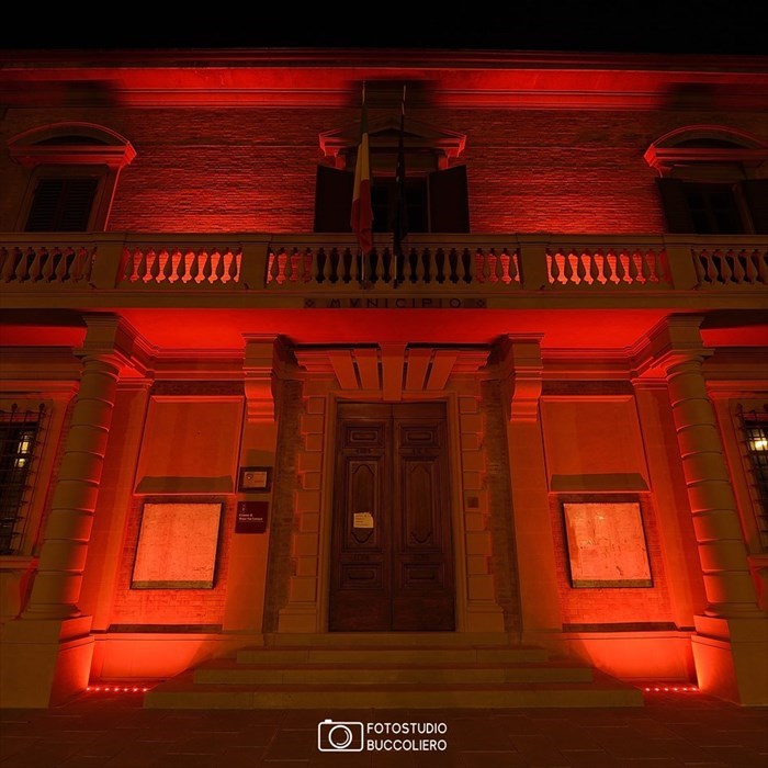 Municipio illuminato di rosso a Borgo